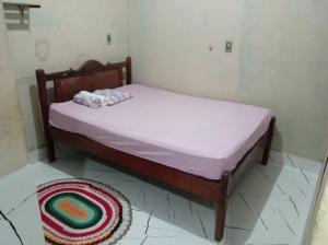 a small bed in a room with a rug on the floor at Casa próximo a praia in Salvaterra