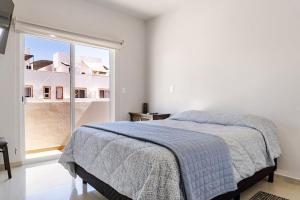 a bedroom with a bed and a large window at SHINYADO Casa de Huéspedes Cabo San Lucas in Cabo San Lucas +27 photos