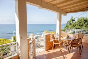 a patio with a table and chairs and the ocean at Oceanfront Studio at Paramonas Beach in Paramonas +17 photos