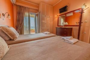 two beds in a room with a view of the ocean at Oceanfront Studio at Paramonas Beach in Paramonas