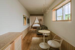 ein Zimmer mit einem Bett, einer Couch und einem Tisch in der Unterkunft NANUKA hotel in Kirishima