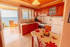 a kitchen with a table and a view of the ocean at Oceanfront Studio at Paramonas Beach in Paramonas