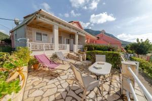 a patio with chairs and a table in front of a house at Oceanfront Studio at Paramonas Beach in Paramonas