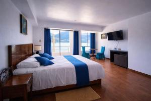 a bedroom with a large bed with blue pillows at Mi Hacienda Pacucha in Andahuaylas