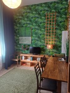 a dining room with a table and a green wall at Ku'damm Taler's Central - Self Check In in Berlin