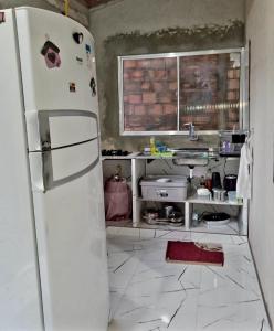 a kitchen with a white refrigerator and a tile floor at Casa próximo a praia in Salvaterra