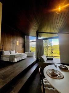 a bedroom with a bed and a table in a room at Cabanas Grande Passo in Quatro Barras