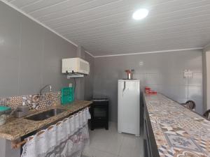 a kitchen with a sink and a refrigerator at Hospedagem Doce Lar - Casa Manacá in Teresópolis