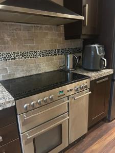 a kitchen with a stainless steel stove top oven at Stylish Home With Full Amenities in Yiewsley