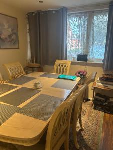 a dining room with a table and chairs and a window at Stylish Home With Full Amenities in Yiewsley