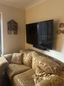 a living room with a couch and a flat screen tv at Stylish Home With Full Amenities in Yiewsley