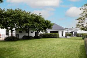 a white house with a large yard at The Deco Retreat in Hawera