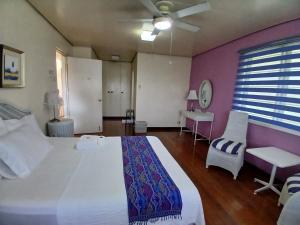 a bedroom with a large white bed and a chair at Casa Joaquin BnB in Manila