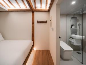 a small bathroom with a bed and a toilet at Luxury Hanok The four beauties seochon in Seoul +5 photos