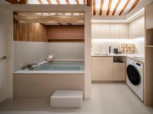 a bathroom with a tub in the middle of a kitchen at Luxury Hanok The four beauties seochon in Seoul