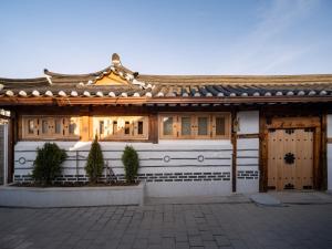 a japanese house with a wooden roof at Luxury Hanok The four beauties seochon in Seoul
