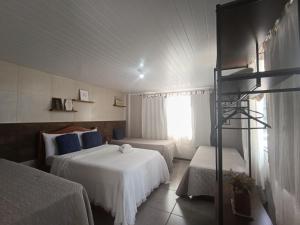 a hotel room with two beds and a window at Hospedagem Doce Lar - Casa Manacá in Teresópolis +31 photos
