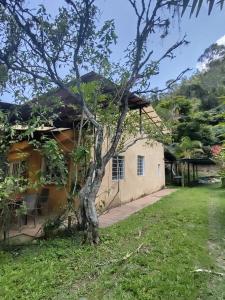 a house with a tree in the yard at Posada San Jorge in Pacho