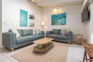 a living room with two couches and a table at Sandpiper 11 in Smiths Lake