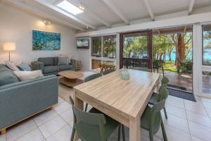 a living room with a wooden table and chairs at Sandpiper 11 in Smiths Lake