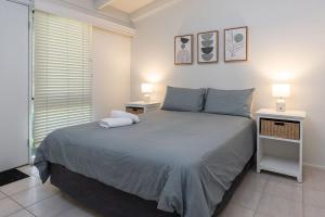 a bedroom with a large bed with two night stands at Sandpiper 11 in Smiths Lake