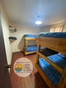 a room with two bunk beds and a sign that says canyon challenger aleamed at cabañas canemar in Hueyilemu