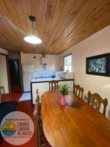 a kitchen and dining room with a wooden table at cabañas canemar in Hueyilemu