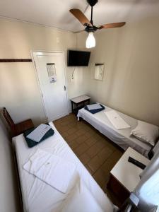 a room with two beds and a ceiling fan at Modenesi Hotel in Linhares