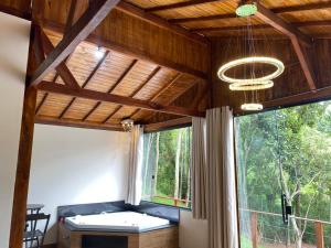 a living room with a large window and a couch at Cabana Dream Garden in Nova Friburgo