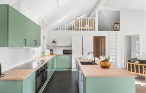 a kitchen with green and white cabinets and a sink at Amazing Home In Idestrup With Sauna in Bøtø By