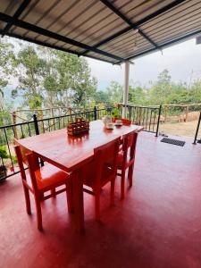 a wooden table and chairs sitting on a porch at Mount View Plaza - Ella Cottage with Mountain &Valley View in Ella +25 photos