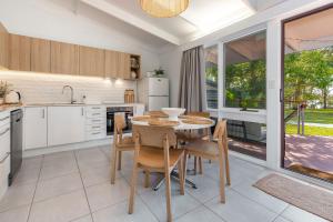 a kitchen with a table and chairs in a kitchen at Sandpiper 4 in Smiths Lake