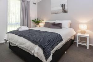 a bedroom with a large bed and a window at Sandpiper 4 in Smiths Lake