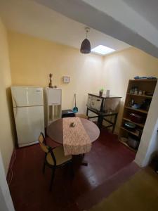 a kitchen with a table and a refrigerator at Casitadelavid in Capilla del Monte