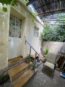 a house with a porch with a door and a chair at Casitadelavid in Capilla del Monte