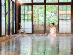 a woman in a white dress standing in a swimming pool at Futsukaichi Hot Spring - Daimaru Besso in Chikushino