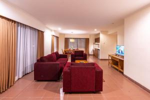 a living room with two red couches and a television at Plagoo Holiday Hotel in Nusa Dua