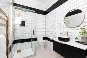 a bathroom with a toilet and a sink and a mirror at The Deco Retreat in Hawera +22 photos