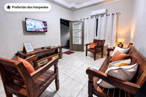 a living room with a couch and a tv at Casa luz e conforto Passos Capitólio in Passos