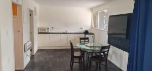 a small kitchen with a table and chairs in it at Kiwi Cove Motel in Taupo