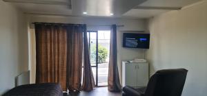 a living room with a door to a patio at Kiwi Cove Motel in Taupo