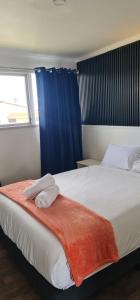 a bedroom with a bed with two towels on it at Kiwi Cove Motel in Taupo