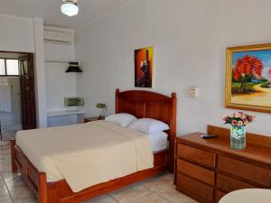 a bedroom with a bed and a table with a vase of flowers at Hotel Garant & Suites in Boca Chica +27 photos