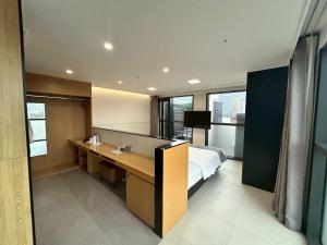 a hotel room with a bed and a desk with a sink at Hotel Skypark DaejeonⅠ in Daejeon