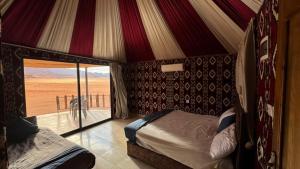 a bedroom with a bed and a view of the desert at elan luxury camp in Disah