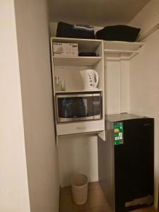 a kitchen with a microwave and a small refrigerator at Cochabamba Mágica - Aniceto Arce - B in Cochabamba