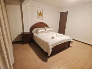 a bedroom with a bed with white sheets and pillows at Cochabamba Mágica - Aniceto Arce - B in Cochabamba