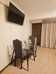a dining room with a table and chairs and a television at Cochabamba Mágica - Aniceto Arce - B in Cochabamba