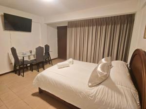 a hotel room with a bed and a table with chairs at Cochabamba Mágica - Aniceto Arce - B in Cochabamba