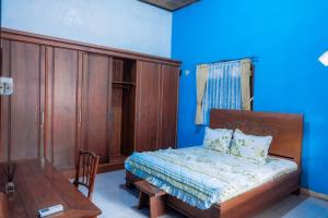 a small bedroom with a bed and a table at Jeru Homestay in Situbondo